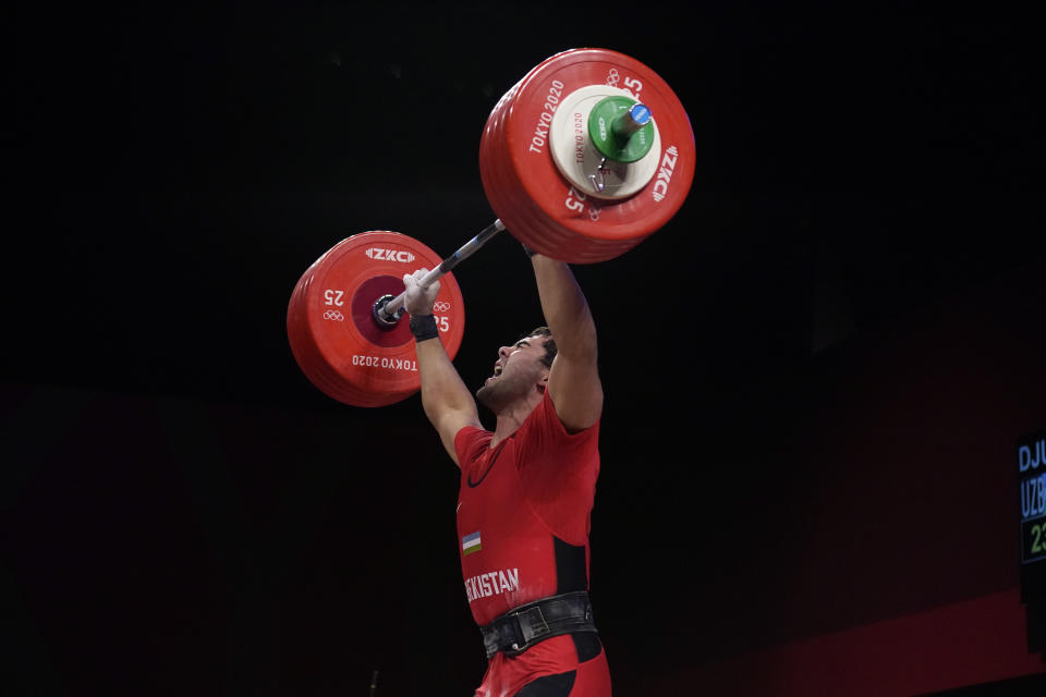 Akbar Djuraev of Uzbekistan completes his final lift, to set a new Olympic record, in the men's 109kg weightlifting event at the 2020 Summer Olympics, Tuesday, Aug. 3, 2021, in Tokyo, Japan. (AP Photo/Seth Wenig)