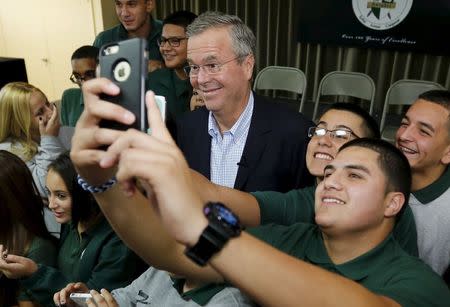 Former Florida Governor and Republican candidate for president Jeb Bush poses with a student following a town hall with high school students at La Progresiva Presbyterian School in Miami, Florida, September 1, 2015. REUTERS/Joe Skipper