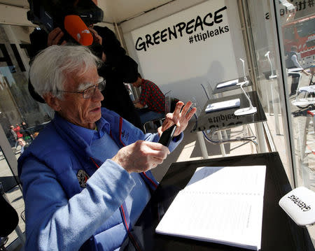 Christian Stroebele, member of the lower house of parliament Bundestag and of the Green Party, takes a picture of a copy of the leaked TTIP negotiations inside a public reading room by the environmental campaign group Greenpeace in front of the Brandenburg Gate in Berlin, Germany, May 2, 2016. REUTERS/Fabrizio Bensch