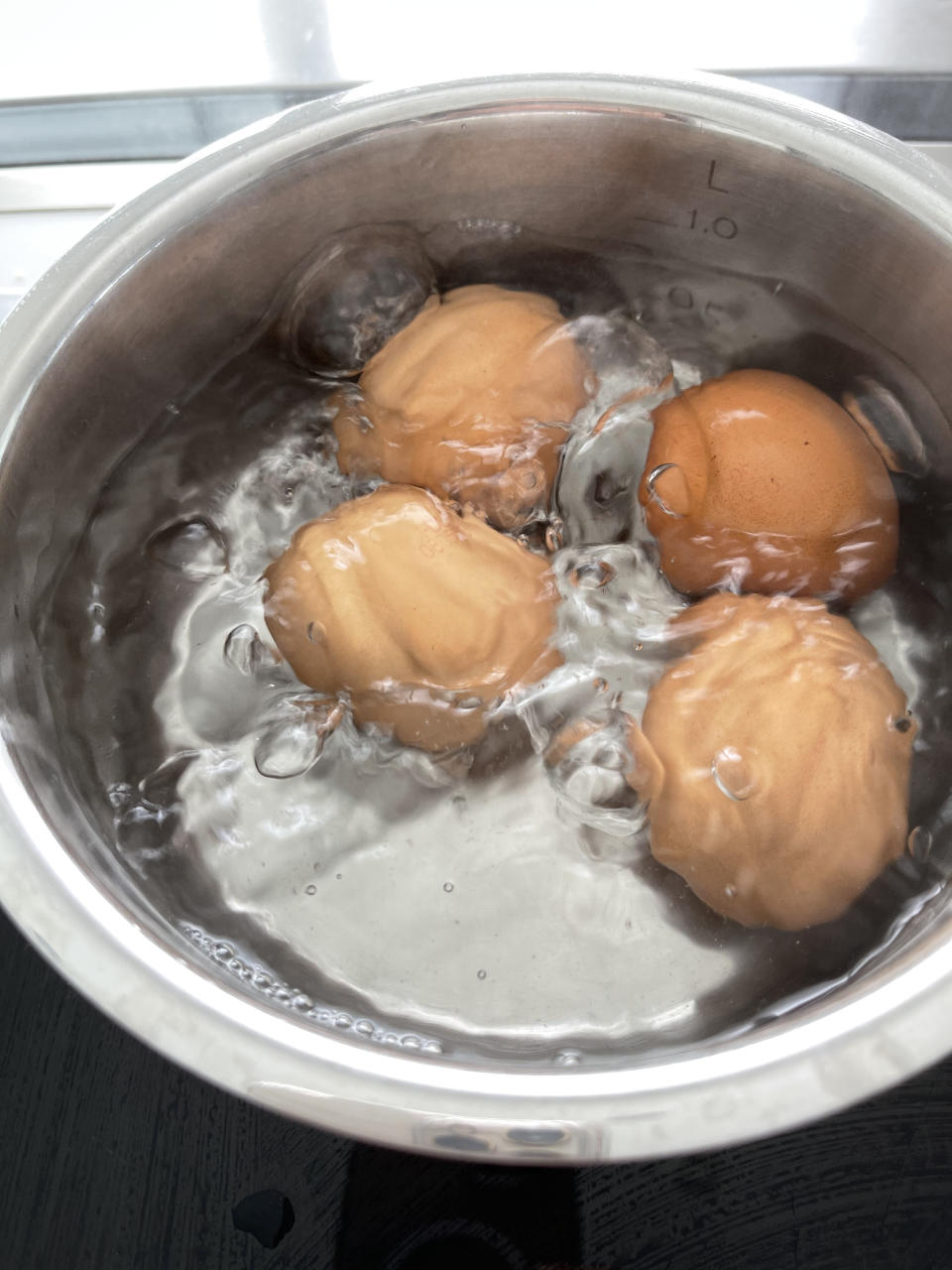 Eggs boiling in a pot.