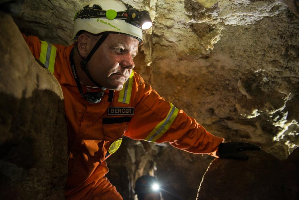 El explorador residente de National Geographic Lee Berger y jefe de la expedición de excavación, en el interior de la cueva Rising Star de Sudáfrica, donde se descubrieron elementos fósiles pertenecientes a H. naledi, una nueva especie de pariente humano (Robert Clark/National Geographic)