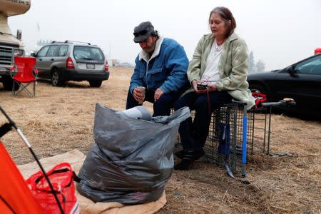 Anna and William Goodnight, of Paradise, sit outside their tent at a makeshift evacuation center for people displaced by the Camp Fire in Chico, California, U.S., November 15, 2018. REUTERS/Terray Sylvester