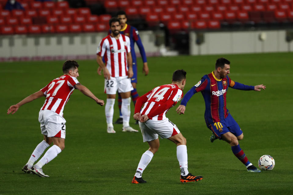 Barcelona's Lionel Messi, right, attempts a shot at goal in front of Athletic Bilbao's Dani Garcia, center, and Athletic Bilbao's Unai Vencedor during the Spanish La Liga soccer match between FC Barcelona and Athletic Bilbao at the Camp Nou stadium in Barcelona, Spain, Sunday, Jan. 31, 2021. (AP Photo/Joan Monfort)