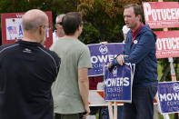 New Hampshire Republican 1st Congressional District Candidate Matt Mowers rests on a campaign sign while talking with voters and campaign volunteers, Tuesday, Sept. 13, 2022, during a stop at a polling station in Derry, N.H. (AP Photo/Charles Krupa)