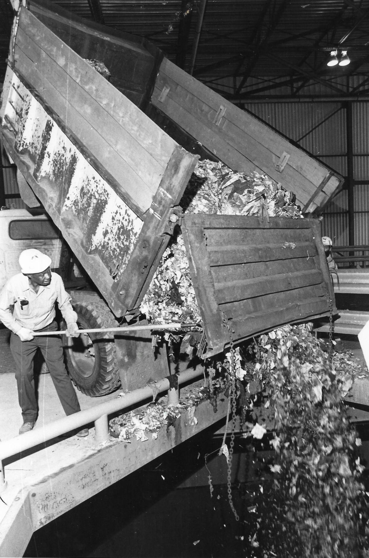 A worker dumps garbage into a storage pit June 22, 1979, at the newly opened Recycle Energy System plant in Akron.