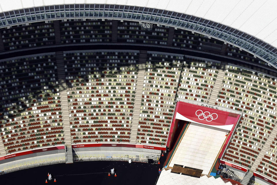 FILE - In this June 21, 2021, aerial file photo, the Olympic Rings are seen with spectators' seats at the National Stadium in Tokyo Japan. The Olympic corporate sponsorship program has been a key part of the Olympic experience since it began in 1985. But all that magic from the Olympic sponsorship is being undermined because of the virus. .(Kyodo News via AP)