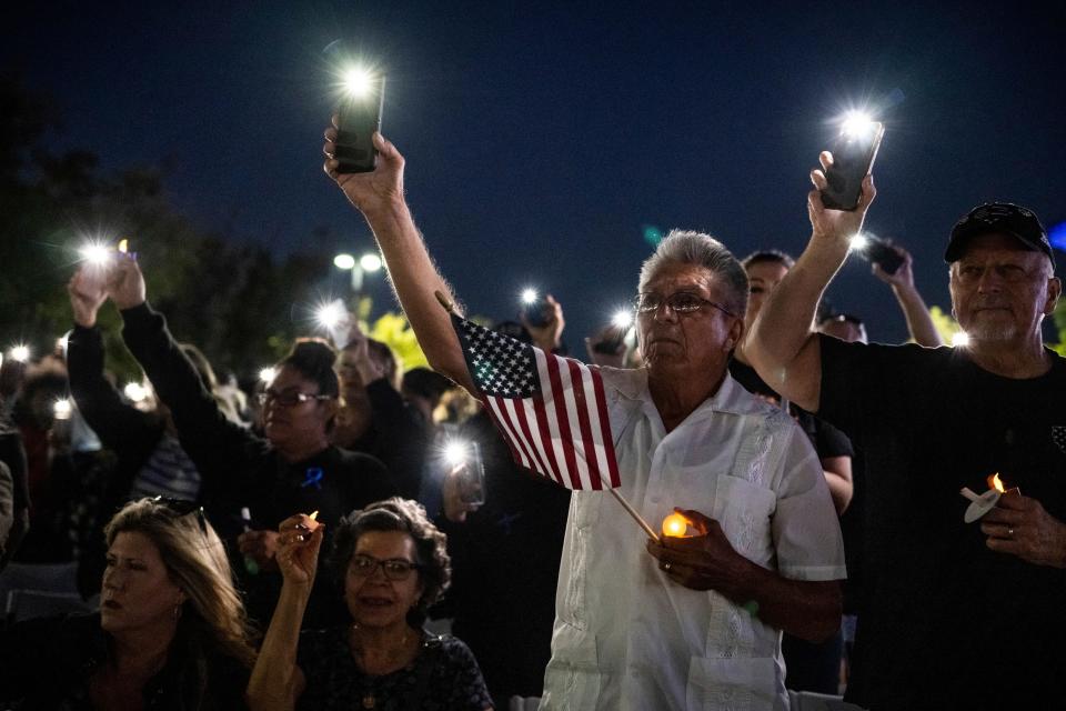 Miguel Ruiz, center, and his wife, Sara, seated, attend a vigil in Palmdale, Calif., for Los Angeles County Sheriff's Deputy Ryan Clinkunbroomer at the Palmdale Sheriff's Station on Sept. 17, 2023.