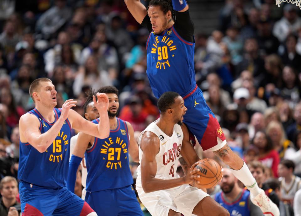 Cleveland Cavaliers forward Evan Mobley (front right) is fouled by Denver Nuggets forward Aaron Gordon (back right) as Nuggets center Nikola Jokic (left) and guard Jamal Murray (second from left) look on in the second half of an NBA basketball game on Jan. 6, 2023, in Denver.