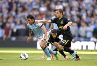 Manchester City's Carlos Tevez and Wigan Athletic's Shaun Maloney (right) battle for the ball