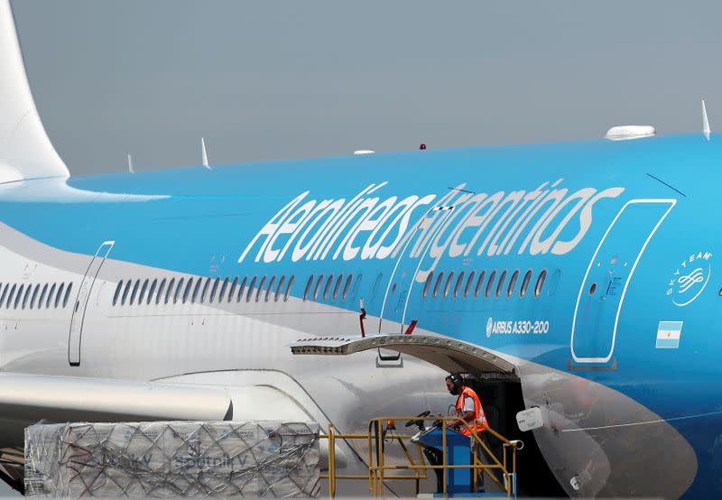 Un trabajador descarga neveras portátiles con dosis de la vacuna contra el COVID-19 Sputnik V, en el Aeropuerto Internacional de Ezeiza, en Buenos Aires, Argentina