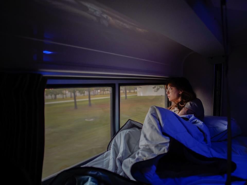 The author lays in the train bed looking out the window on the left side