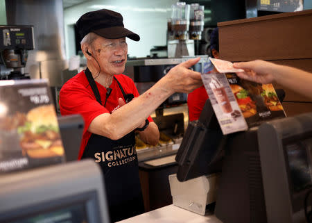 Martin Seah works at the cashier at a McDonald's restaurant outlet in Singapore December 19, 2018. REUTERS/Edgar Su/Files