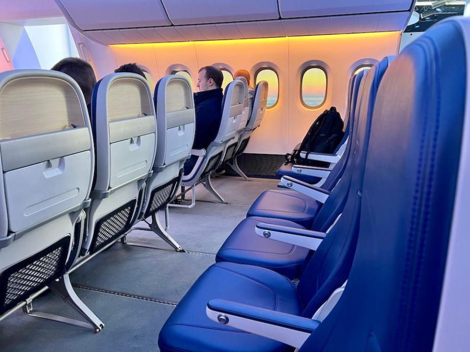 Boeing 777X interior cabin mockup display, showing an example economy seat row