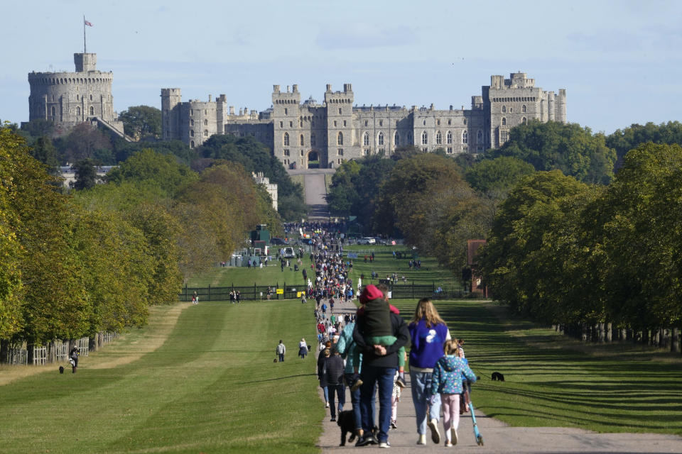 People make their way along the Long Walk towards Cambridge gate outside Windsor Castle to lay flowers for the late Queen Elizabeth II in Windsor, England, Sunday, Sept. 18, 2022. The Queen will lie in state in Westminster Hall for four full days before her funeral on Monday Sept. 19. (AP Photo/Gregorio Borgia)