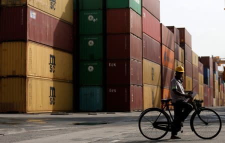 An operator works as shipping containers are seen at the background at the main port in Colombo