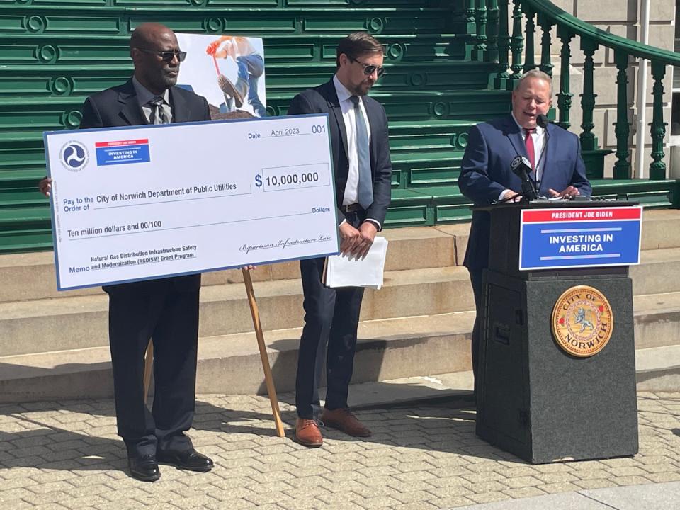 Chief Investigator Mitch Brown and Deputy Administrator Tristan Brown of the Pipeline and Hazardous Materials Safety Administration stand beside NPU General Manager Chris LaRose, as he accepts $10 million in federal funding to help replace gas mains in the city.