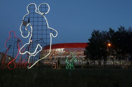 FILE PHOTO: Neon light decorations in the shape of soccer players stand in front of the Mordovia Arena in Saransk, Russia June 27, 2018. REUTERS/Ricardo Moraes/File Photo/File Photo/File Photo