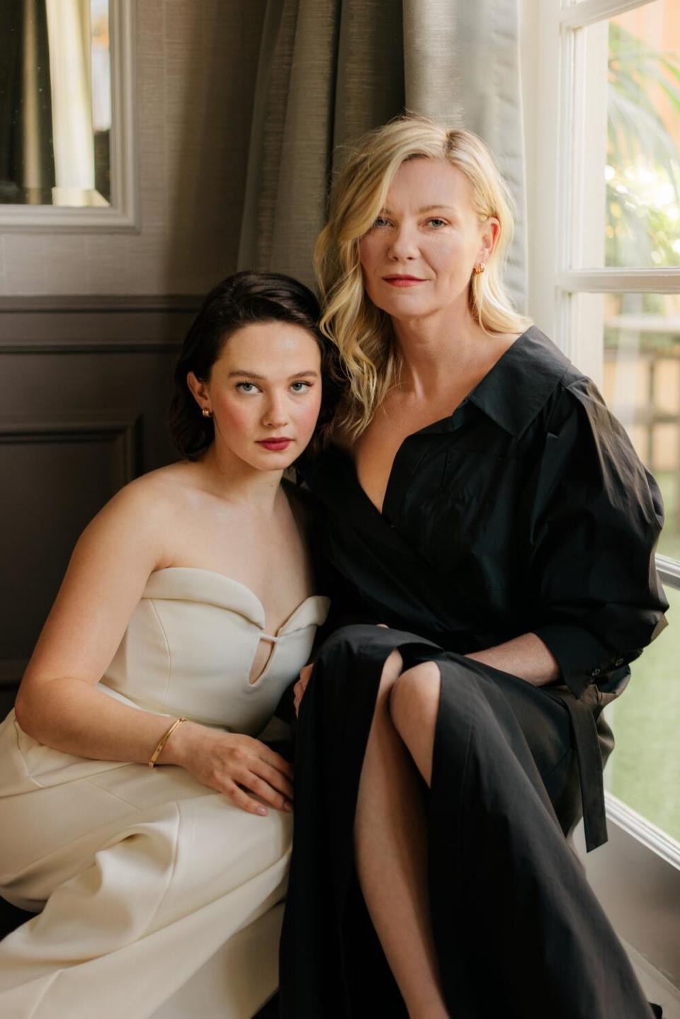 Two women in dresses pose for the camera.