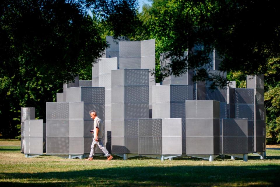 People walk around a sculpture entitled