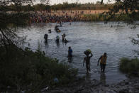 Migrants wade across the Rio Grande from Del Rio, Texas, to Ciudad Acuña, Mexico, Sunday, Sept. 19, 2021. (AP Photo/Felix Marquez)