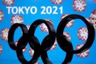 A 3D printed Olympics logo is seen in front of displayed "Tokyo 2021" words in this illustration