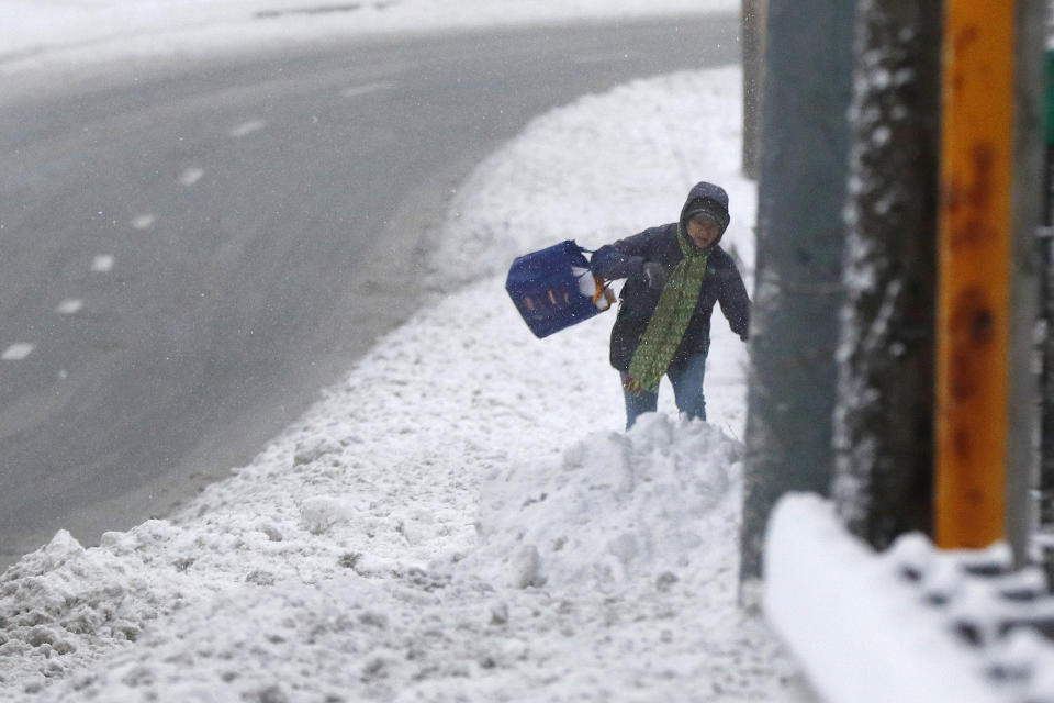 A pedestrian walks through deep snow after an overnight snowfall, Monday, Dec. 2, 2019, in Marlborough, Mass. (AP Photo/Bill Sikes)