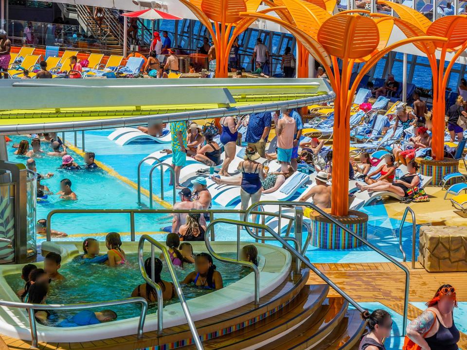 A crowded pool deck on a colorful cruise ship