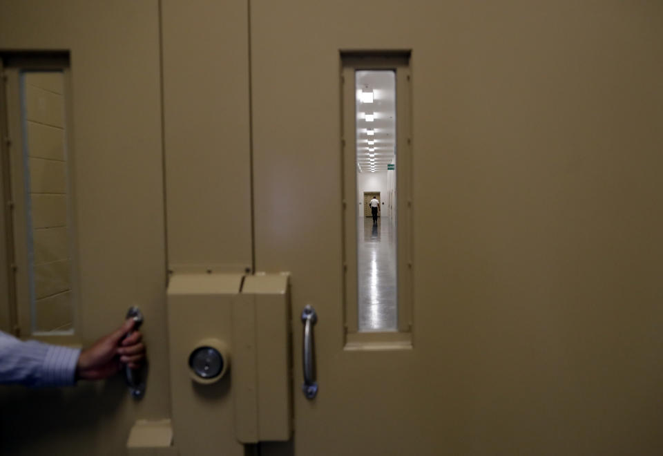 A man walks in a hallway at the Otay Mesa Detention Center Wednesday, Aug. 23, 2017, in San Diego. The facility was at the center of the first big novel coronavirus outbreak at a U.S. immigration detention center in April 2020. (AP Photo/Gregory Bull)