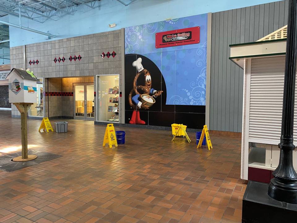 Buckets and caution signs sit on the ground inside Carnation City Mall on Friday, January 21, 2022. The buckets appeared to be catching water that leaked from the ceiling.