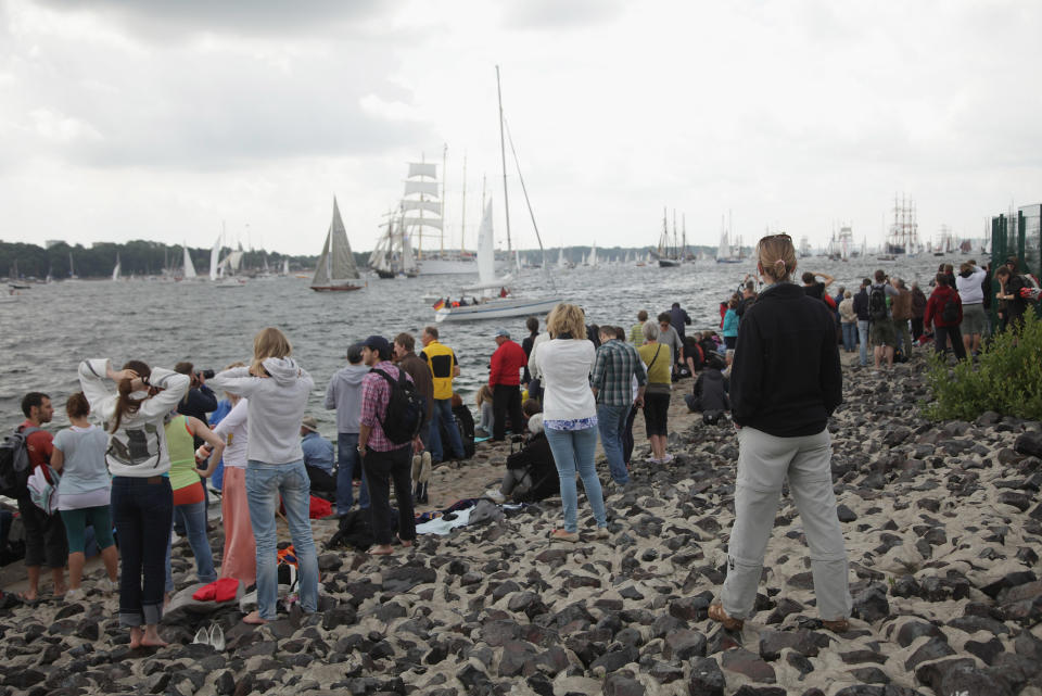 Visitors watch the Windjammer Parade of tall ships on June 23, 2012 in Kiel, Germany. The parade, which features approximately 100 tall ships and traditional large sailing ships, is the highlight of the Kieler Woche annual sailing festival, which this year is celebrating its 130th anniversary and runs from June 16-24. (Photo by Sean Gallup/Getty Images)