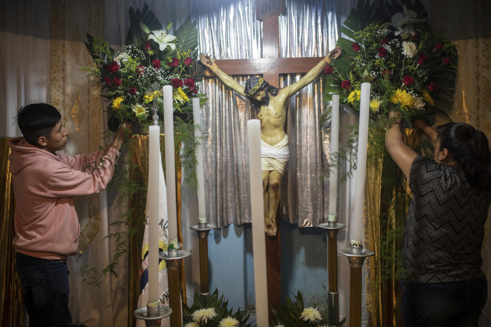 Familiares de tres jóvenes mexicanos, que estaban entre un grupo de migrantes fallecidos a causa del calor y la deshidratación en un tráiler abandonado por traficantes de personas a las afueras de San Antonio, Texas, en junio, preparan un altar antes de la llegada de los féretros a San Marcos Atexquilapan, en el estado de Veracruz, México, el 13 de julio de 2022. (AP Foto/Félix Márquez)