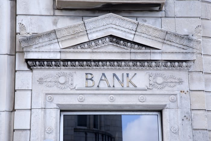 Entrance to a building with the word bank engraved over the doorway.