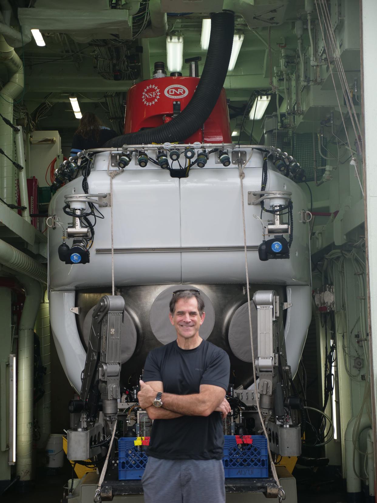Falmouth resident Bruce Strickrott, lead pilot for the Woods Hole Oceanographic Institution's submersible Alvin, stands in front of the submersible during a research cruise in 2022.