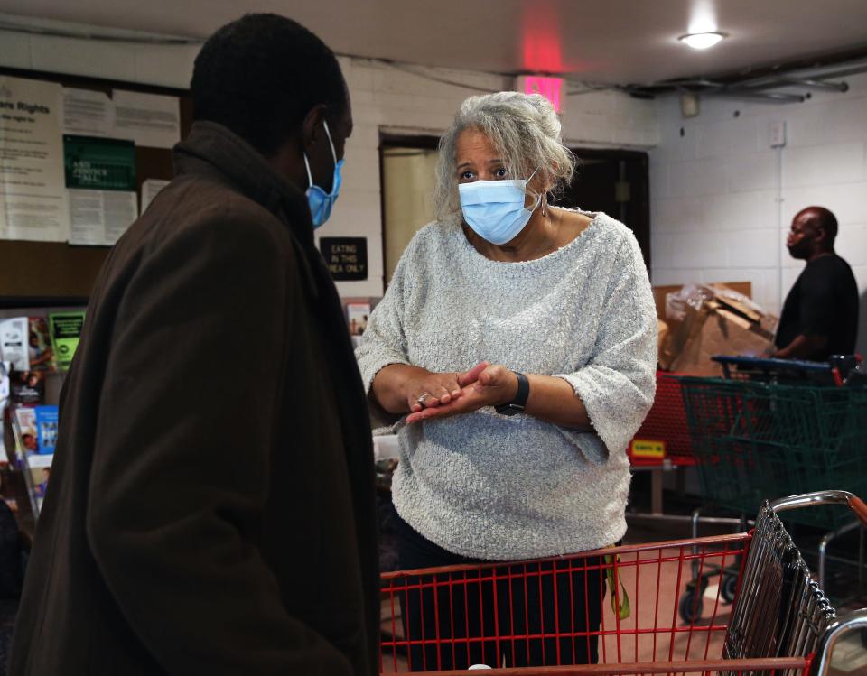 Ascension Wisconsin parish nurse Julia Means, right,  helps a client at the food pantry  at Ebenezer Health Resource Center in Milwaukee