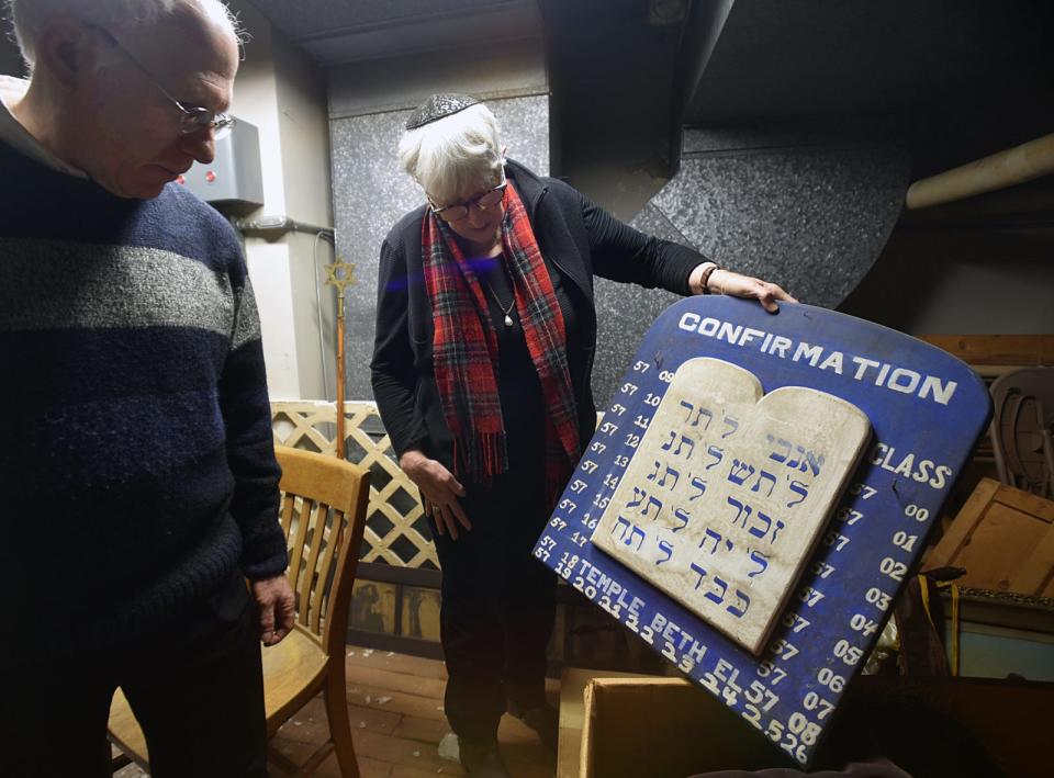 Temple Beth-El Rabbi Mark Elber and Cantor Shoshana Brown hold a plaque in the attic at 385 High St. in Fall River, signifying years in the Jewish calendar. The last year listed is 5726, which in the Gregorian calendar is 1966.