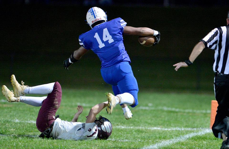 Williamsport's Corry Nelson leaps over Winters Mill's Caleb Crouch and runs the ball in for a touchdown in the first round of the 1A-2A West Region playoff Friday at Williamsport.
