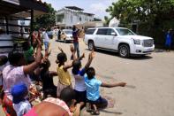 Children raise their arms as Abbe Abekan travels around the streets praying to stop the spread of coronavirus disease (COVID-19), in Abidjan