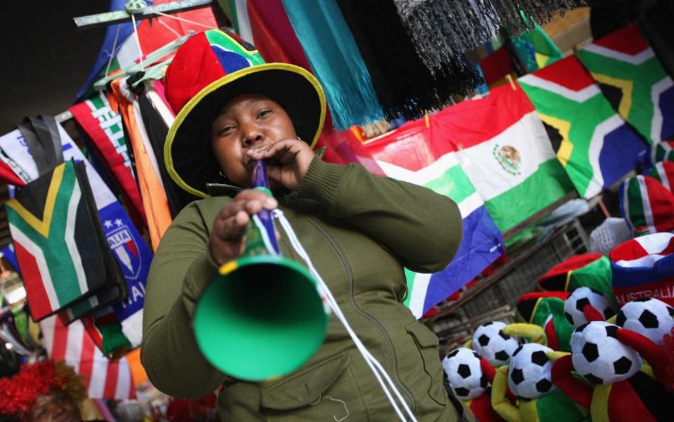 Μια γυναίκα φυσά μια βουβουζέλα σε χρώματα της Νότιας Αφρικής