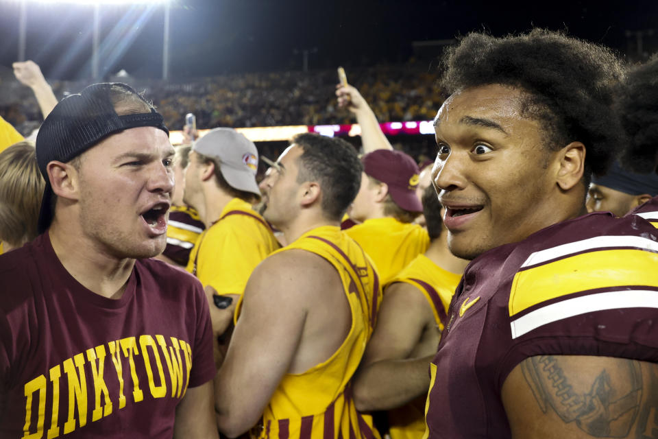 Minnesota running back Darius Taylor, right, celebrates on the field with a swarm of fans after winning an NCAA college football game against Southern California Saturday, Oct. 5, 2024, in Minneapolis. (AP Photo/Ellen Schmidt)