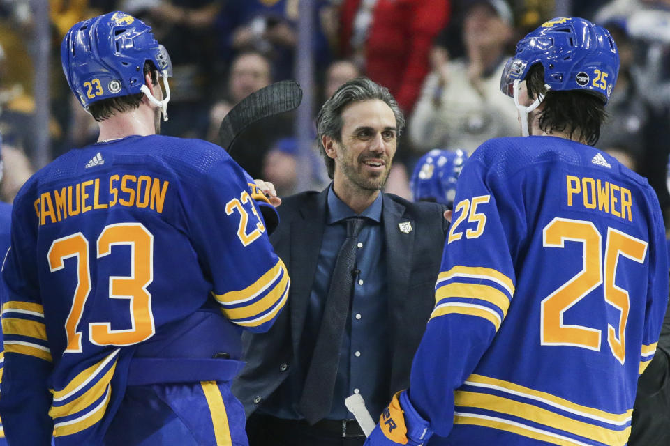 Former Buffalo Sabres goaltender Ryan Miller, center, greets defenseman Mattias Samuelsson (23) and defenseman Owen Power (25) on the ice after the Sabres' overtime win against the New York Islanders on Thursday, Jan. 19, 2023, in Buffalo, N.Y. (AP Photo/Joshua Bessex)