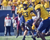 West Virginia wide receiver Sam James (13) picks up yards after a catch against Virginia Tech during the first half of an NCAA college football game in Morgantown, W.Va., Saturday, Sept. 18, 2021. (AP Photo/William Wotring)