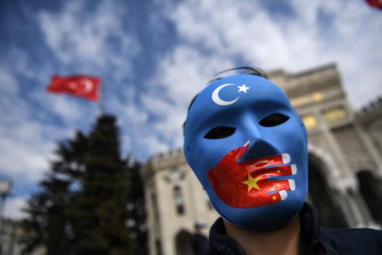 Un manifestante con una máscara pintada con los colores de la bandera de Turkestán Oriental participa en una protesta de partidarios de la minoría uigur el 1 de abril de 2021 en la plaza beyazid de Estambul, Turquía