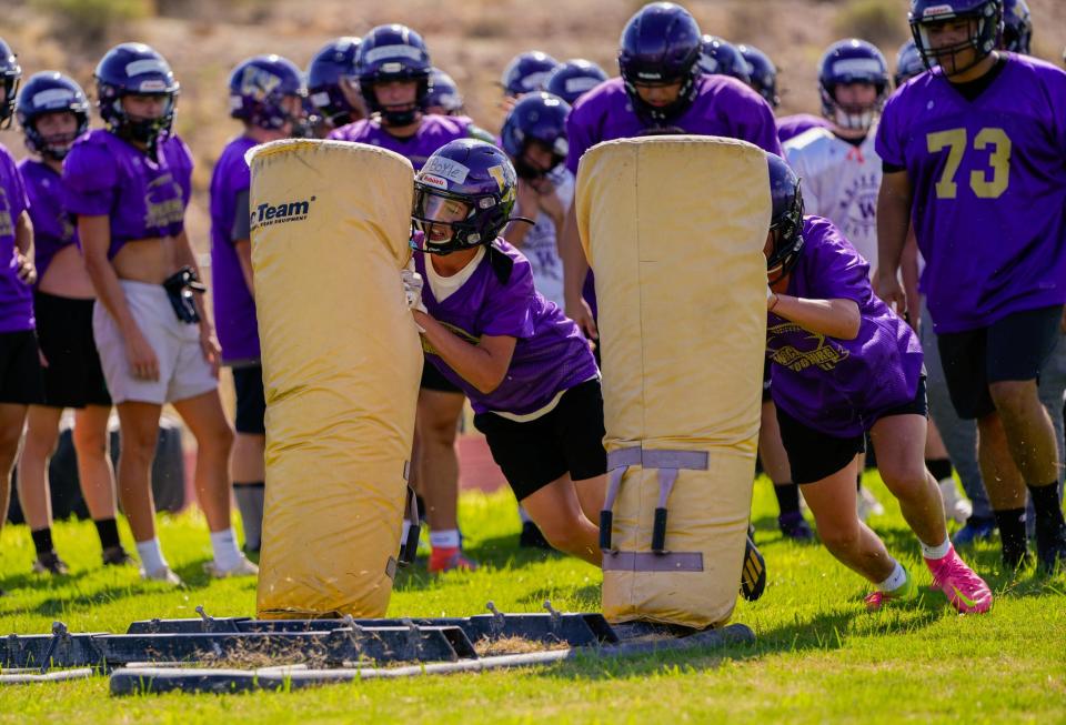 Wickenburg High School football players run drills during practice at the school's football field.