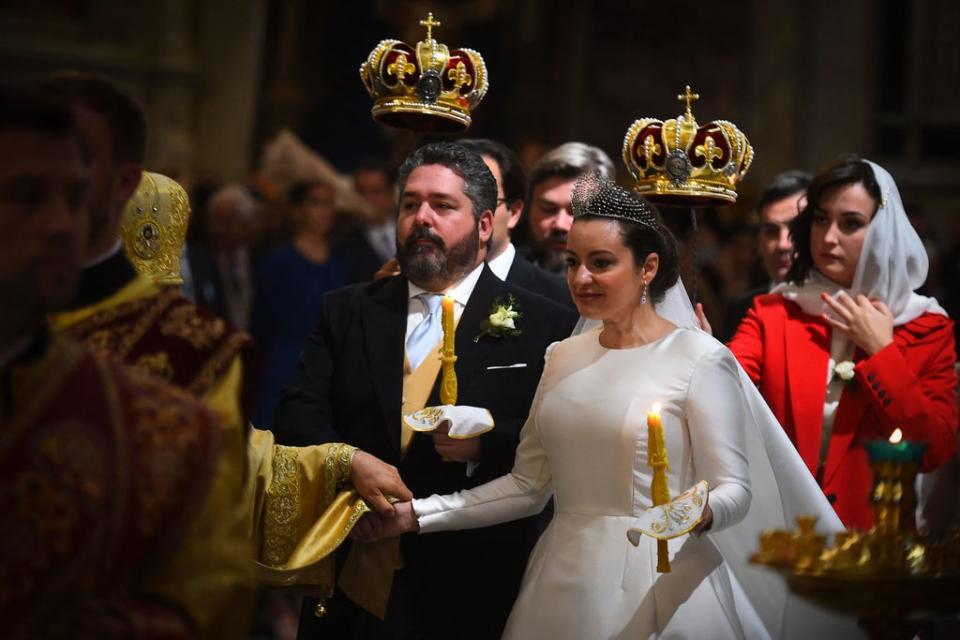 The bride wore a stiff satin long-sleeved gown with a tiara. (AFP via Getty Images)