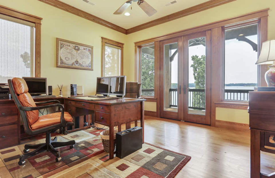 The office has glass doors to a patio overlooking Lake Keowee.