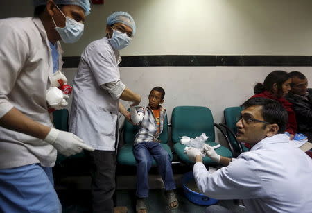 Doctors attend to a boy who was injured during an earthquake, at a trauma center in Kathmandu, Nepal April 26, 2015. REUTERS/Adnan Abidi