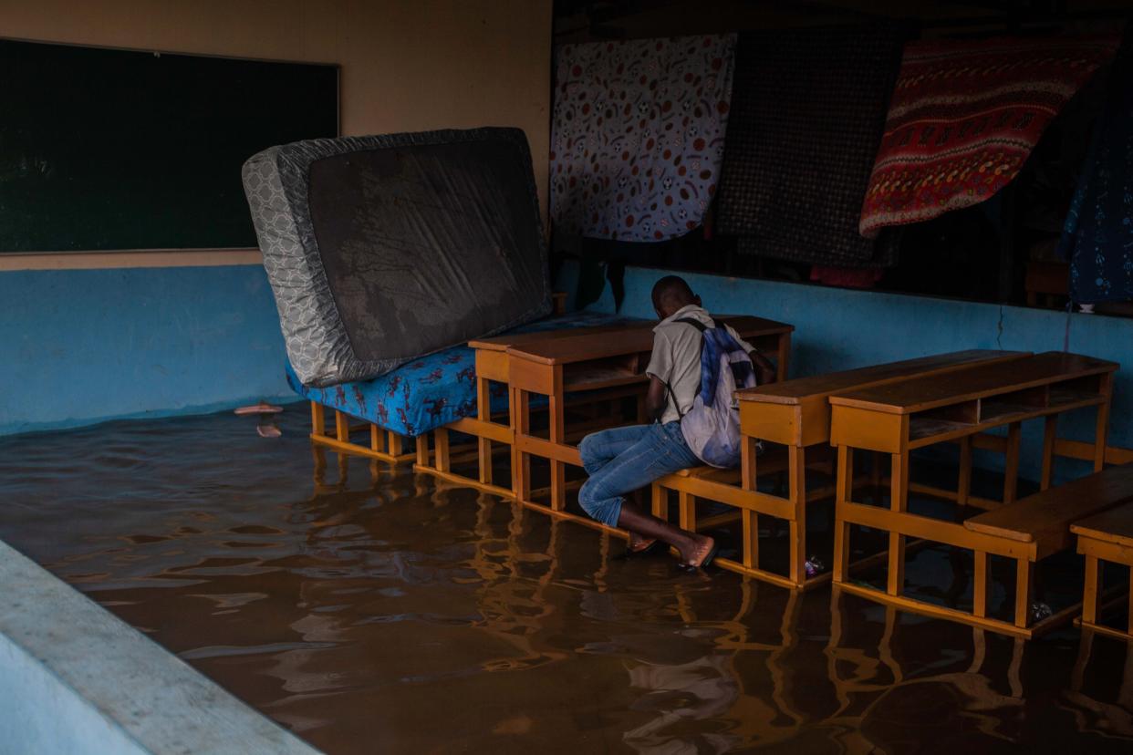 A kid sits at a school classroom bench next to mattresses set up to dry as heavy rain brought by tropical storm Grace hits Haitians just after a 7.2-magnitude earthquake struck Haiti on Aug. 17, 2021, in Les Cayes, Haiti.