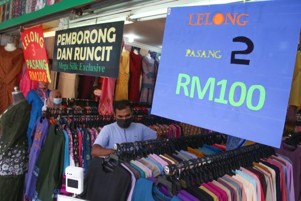 A man browses through clothing at Jalan Masjid India on the eve of Hari Raya Aidilfitri May 12, 2021. — Picture by Choo Choy May