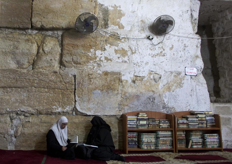 In this photo taken on Monday, Jan. 27, 2014, Palestinian women read at the al-Aqsa mosque compound library in Jerusalem. The library has a collection of some 4,000 old manuscripts with about a quarter considered in poor condition. Half of the books are already undergoing restoration funded by the Waqf, Jordan’s Islamic authority which manages the holy site, and with assistance from UNESCO. (AP Photo/Dusan Vranic)