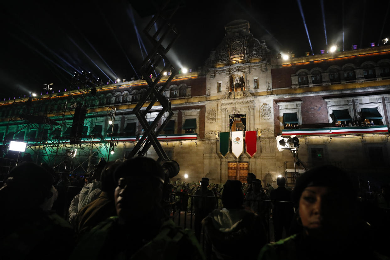 Police provide a security cordon as President Andres Manuel Lopez Obrador and first lady Beatriz Gutierrez Muller look out toward the crowd from the balcony of the National Palace, after Lopez Obrador gave the annual independence shout to kick of Independence Day celebrations at the Zocalo in Mexico City, Sunday, Sept. 15, 2019. Every year the Mexican president marks the "Grito de Dolores," commemorating the 1810 call to arms by priest Miguel Hidalgo that began the struggle for independence from Spain, achieved in 1821.(AP Photo/Rebecca Blackwell)